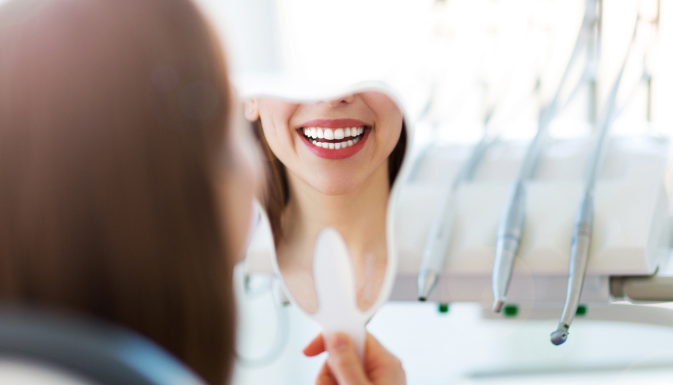 Woman looking at smile after cosmetic dentistry