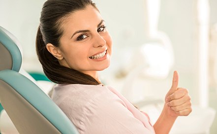 Woman in light pink shirt giving thumbs up