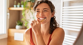 Woman in red shirt brushing her teeth