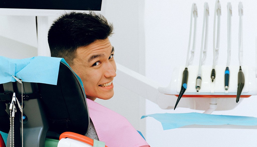 Smiling man in dentist’s chair looking over his shoulder