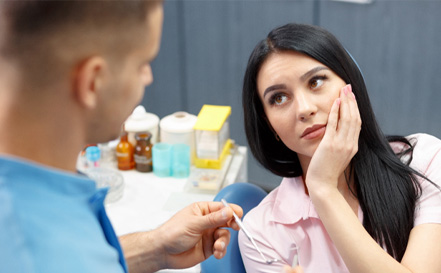 woman visiting dentist because of hurting dental implants