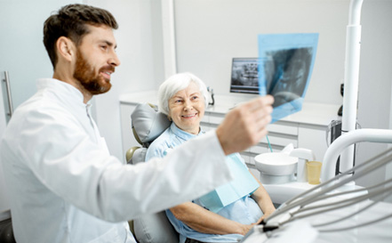 a dentist showing a patient a dental X-ray